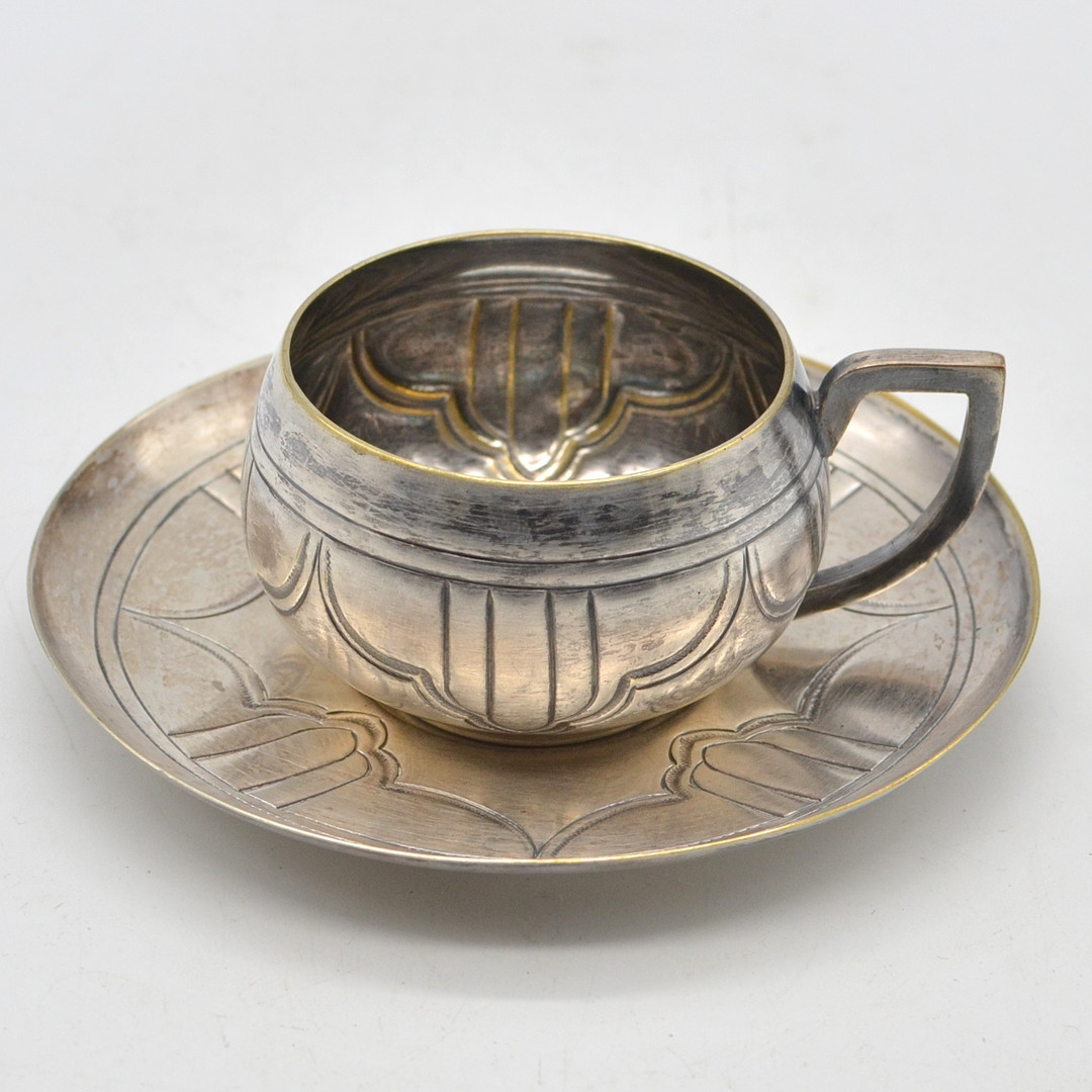 ART DECO DESIGNERTASSE UND UNTERTASSE VON "JH", VERSILBERT, ZISERLIERT, DEUTSCHLAND, FRÜHES 20. JAHRHUNDERT.