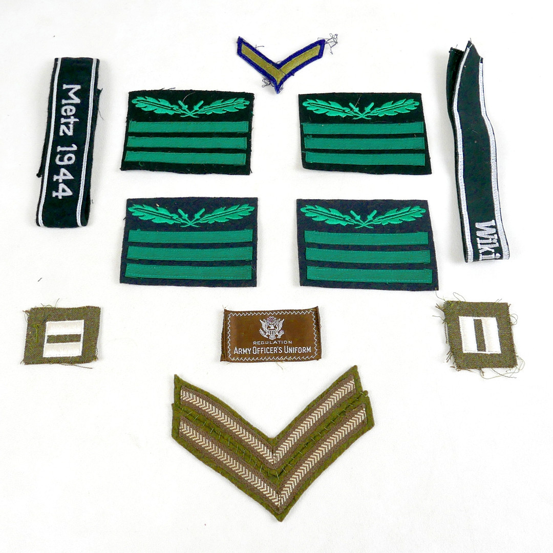 A COLLECTION OF GERMAN AND US WORLD WAR II STYLE UNIFORM CLOTH BADGES AND CUFF TITLES.