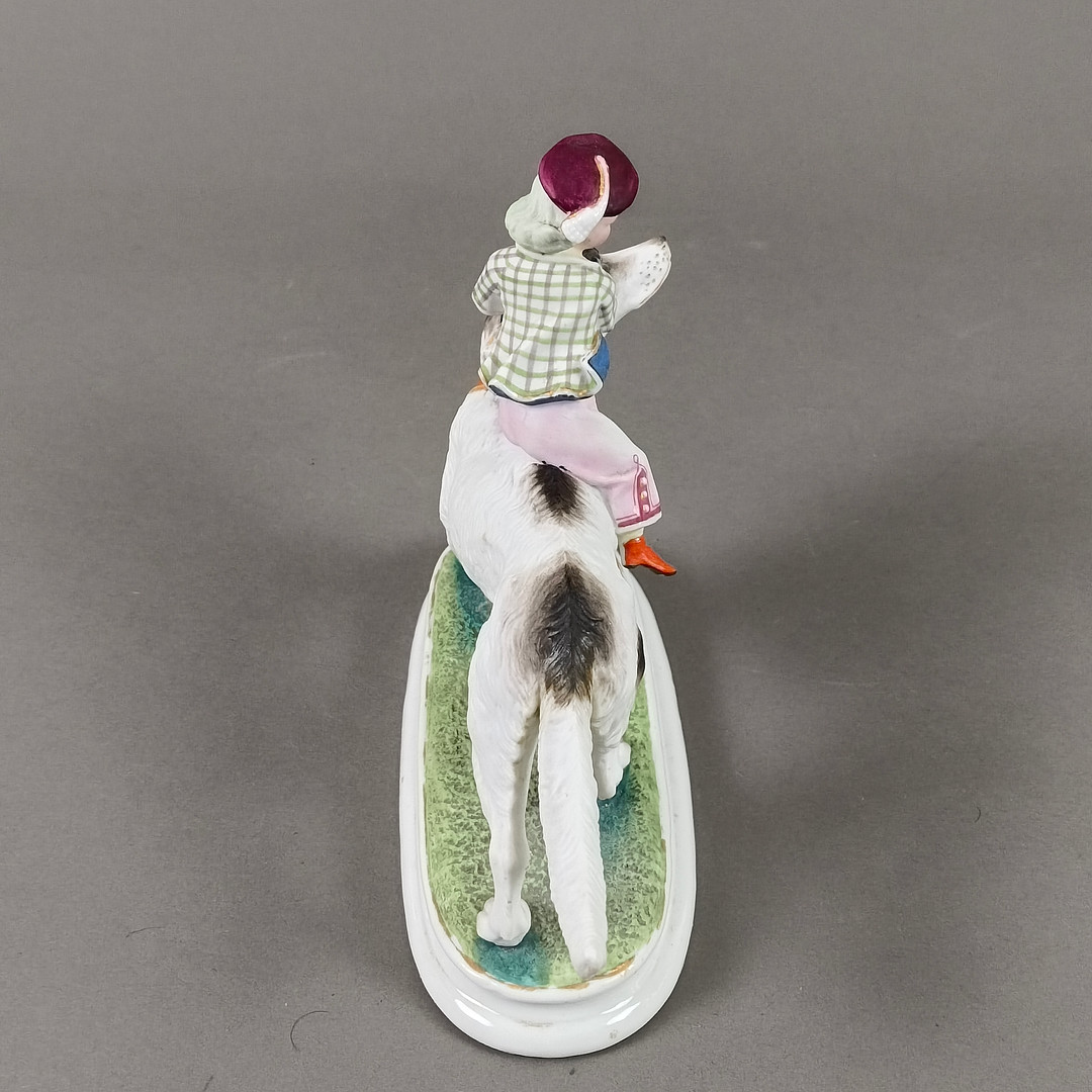 Porzellanfigur Junge auf einem Hund reitend - 20 Jh., wohl Thüringen / Sachsen.