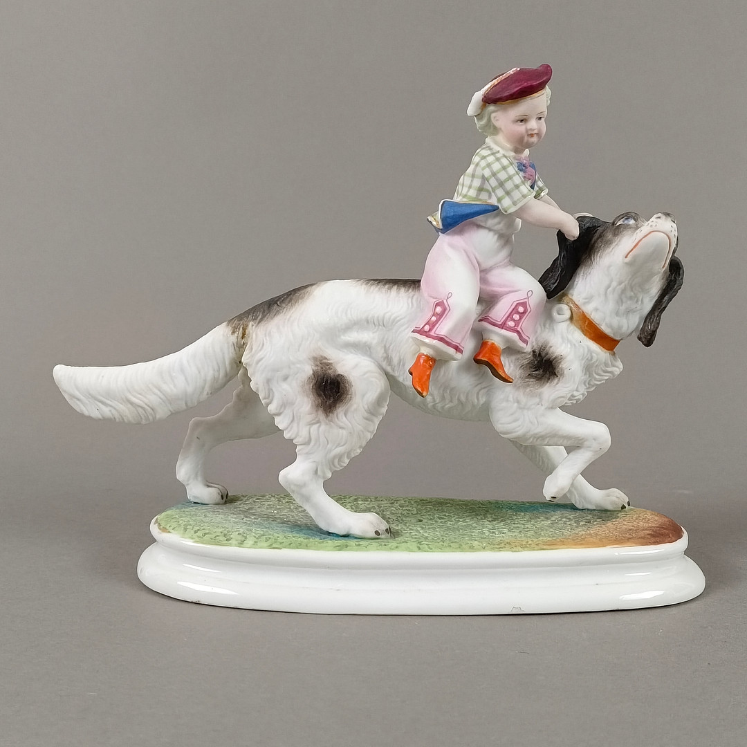 Porzellanfigur Junge auf einem Hund reitend - 20 Jh., wohl Thüringen / Sachsen.