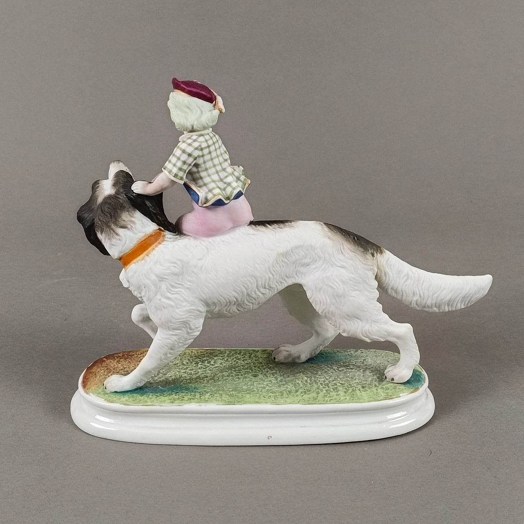 Porzellanfigur Junge auf einem Hund reitend - 20 Jh., wohl Thüringen / Sachsen.