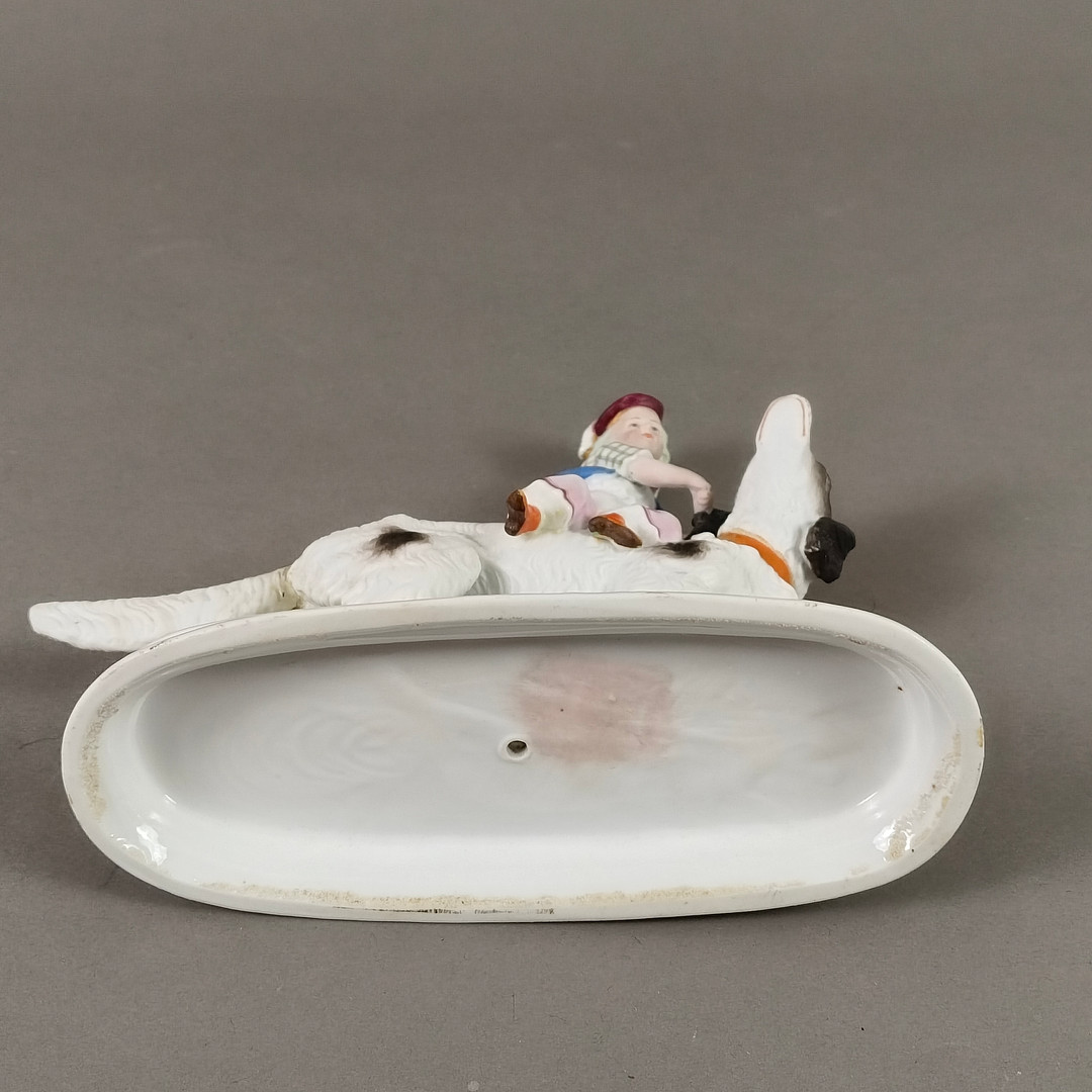 Porzellanfigur Junge auf einem Hund reitend - 20 Jh., wohl Thüringen / Sachsen.