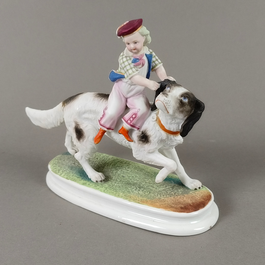 Porzellanfigur Junge auf einem Hund reitend - 20 Jh., wohl Thüringen / Sachsen.