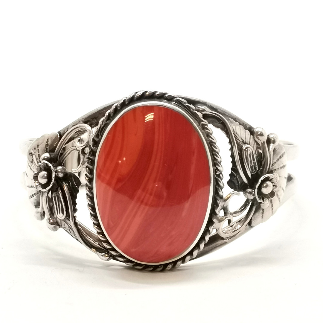 STERLING SILVER BANGLE W/ RED STONE & FLORAL DETAIL.