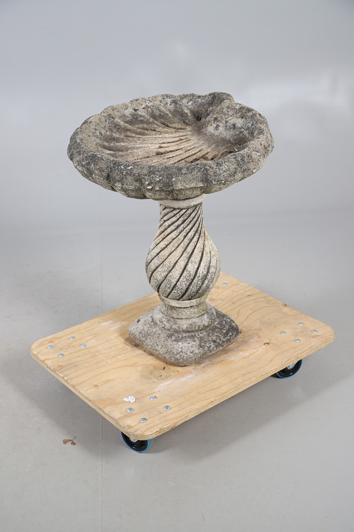 A CONCRETE SHELL SHAPED BIRD BATH.
