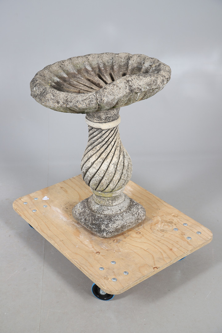 A CONCRETE SHELL SHAPED BIRD BATH.