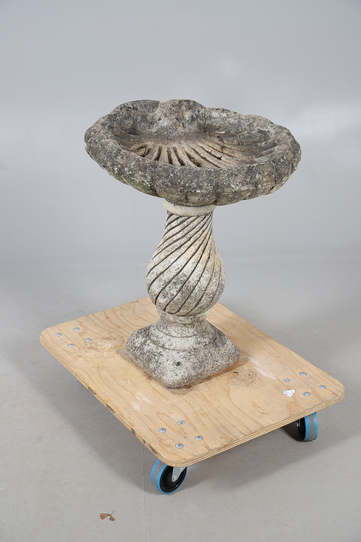 A CONCRETE SHELL SHAPED BIRD BATH.