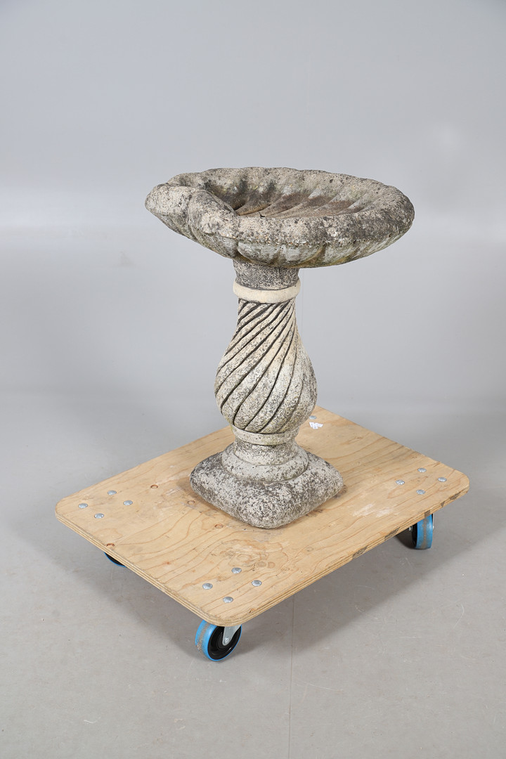 A CONCRETE SHELL SHAPED BIRD BATH.