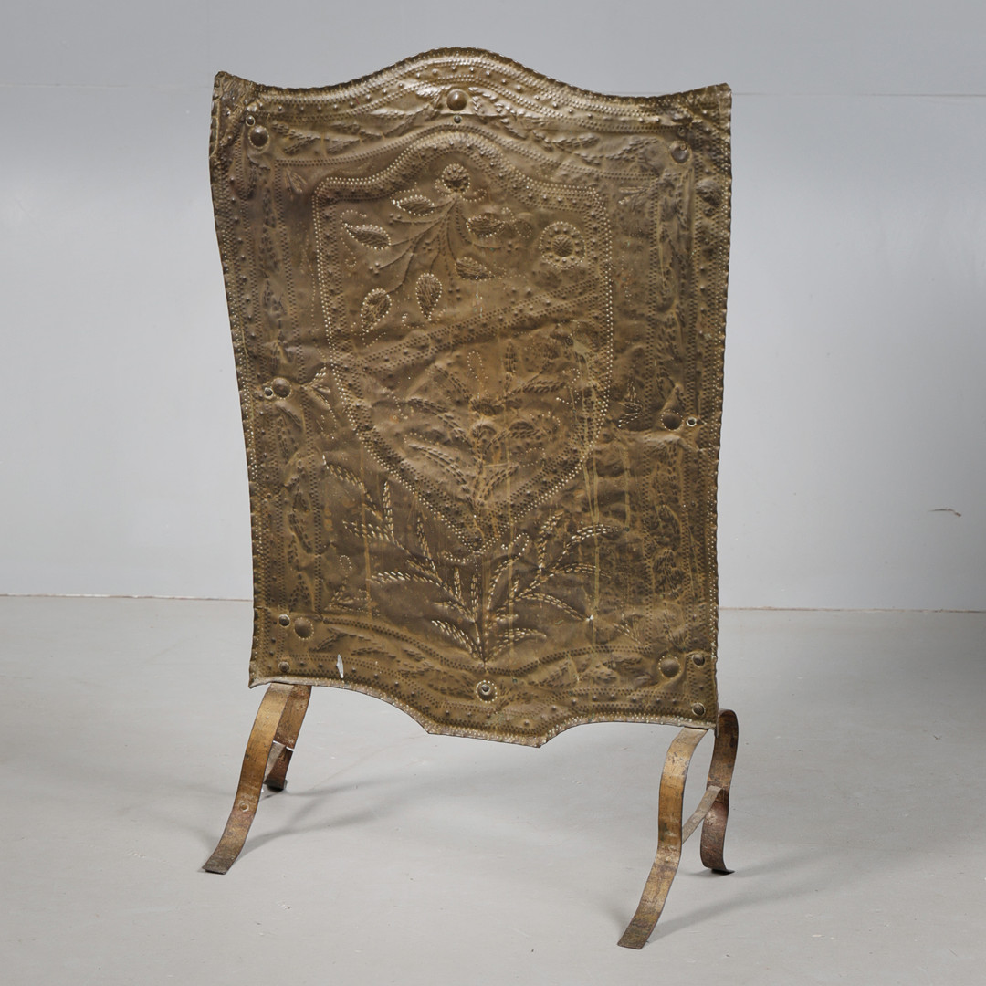 A BRASS HAMMERED FIRE SCREEN.