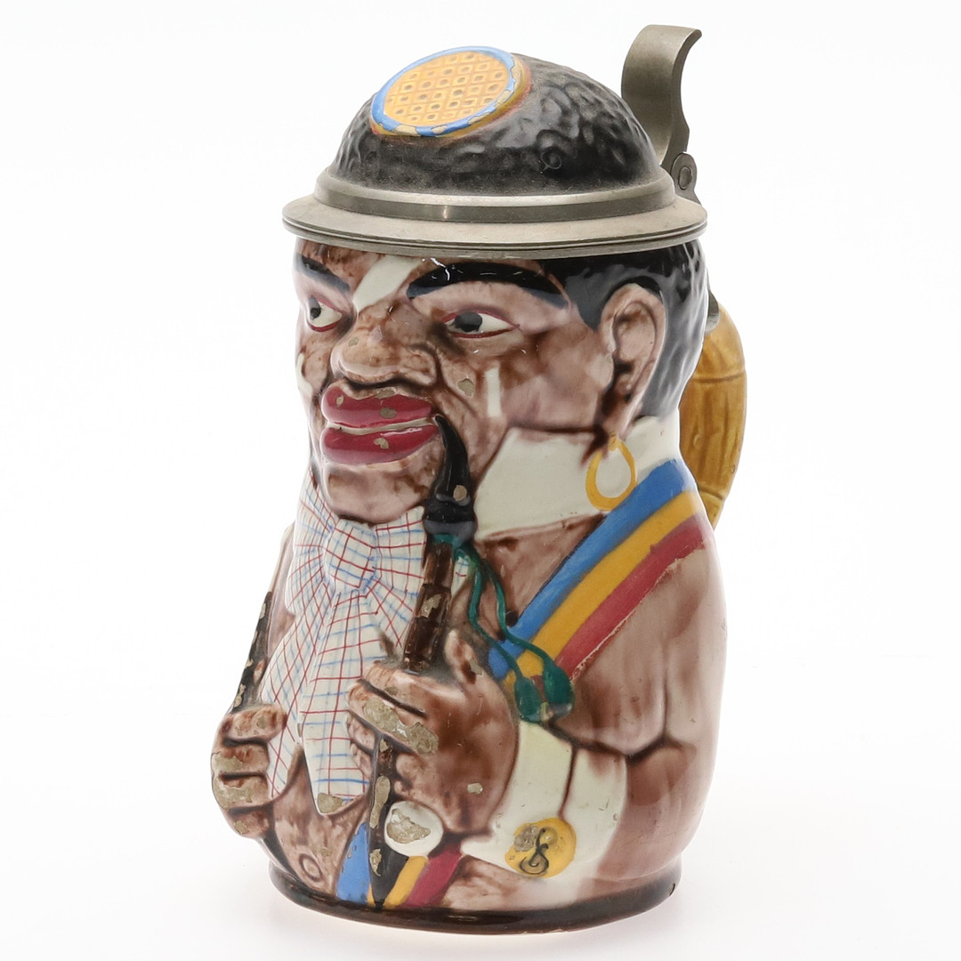 ÖLSEJDEL. Polykromt målat stengods med tennlock, "Der Kamerun-Student", Tyskland, 1800-talets slut.