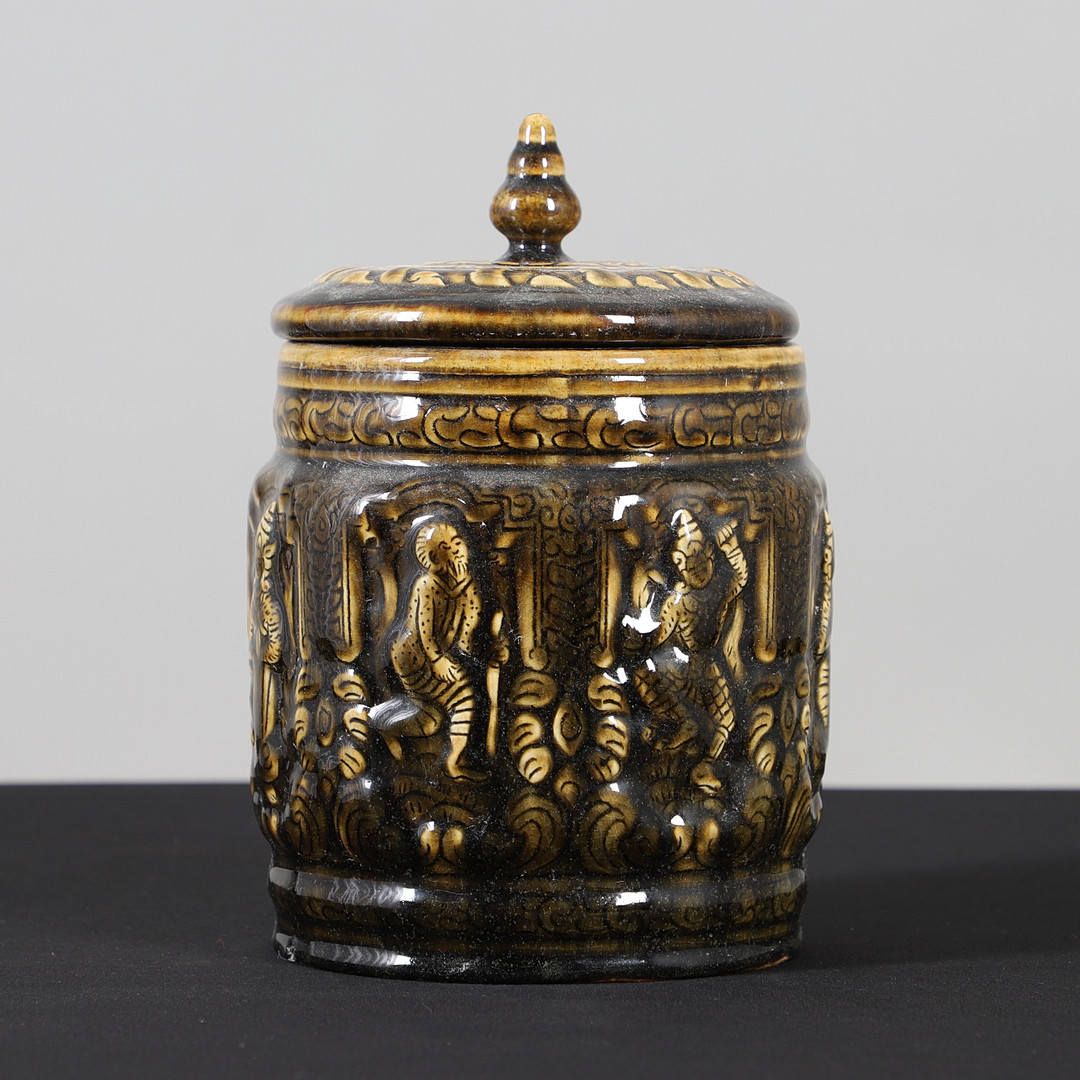 A GLAZED POTTERY JAR AND COVER.