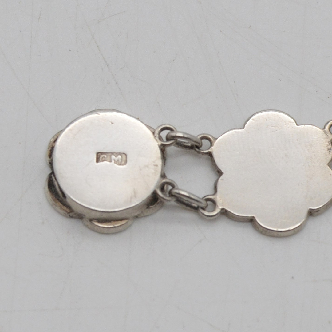 GLIEDERARMBAND MIT CHINESISCHEN GLÜCKSWORTEN, FASSUNG AUS STERLINGSILBER, BLUMENFORM, VON "C.M.", MITTE 20. JH.