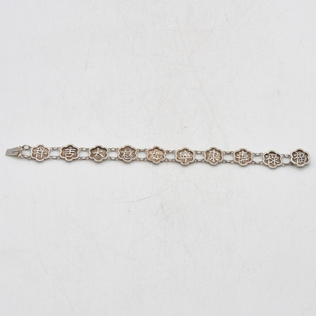 GLIEDERARMBAND MIT CHINESISCHEN GLÜCKSWORTEN, FASSUNG AUS STERLINGSILBER, BLUMENFORM, VON "C.M.", MITTE 20. JH.