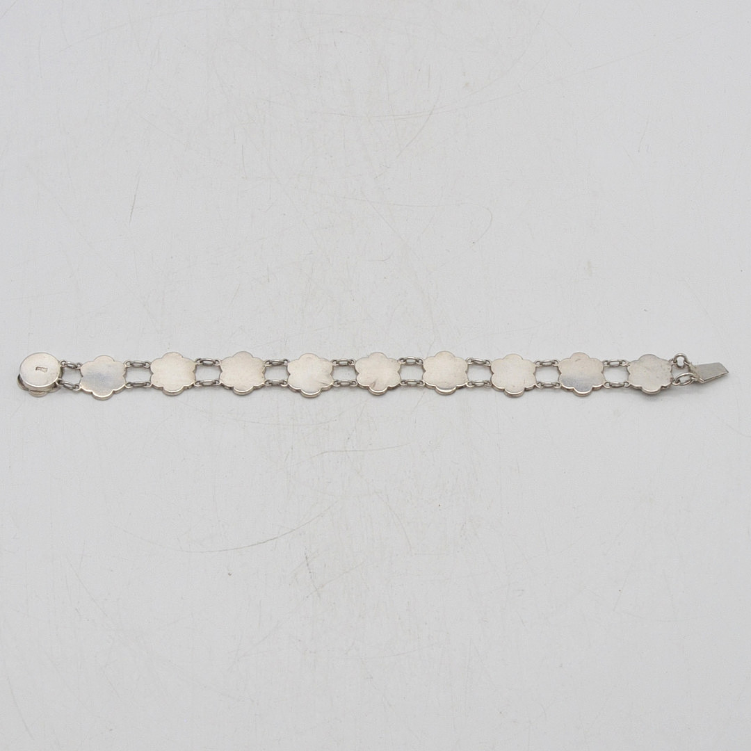 GLIEDERARMBAND MIT CHINESISCHEN GLÜCKSWORTEN, FASSUNG AUS STERLINGSILBER, BLUMENFORM, VON "C.M.", MITTE 20. JH.