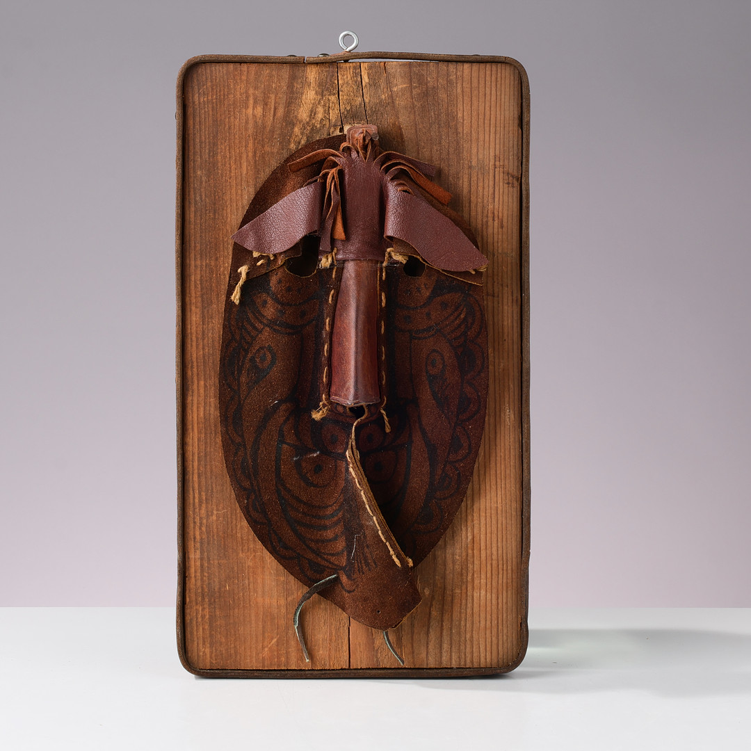 UBEKENDT KUNSTNER. Maske af læder monteret på træ, 1900 tallets anden halvdel.
