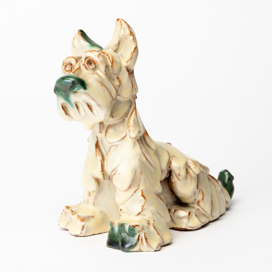 FIGURIN, glaserat lergods, sittande hund, 1900-talets första hälft.