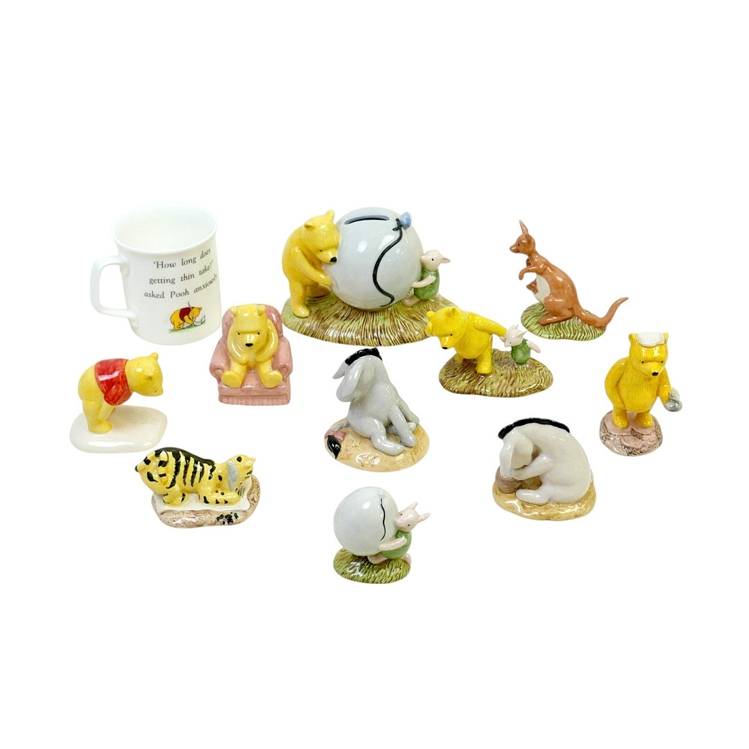 ELEVEN ROYAL DOULTON WINNIE-THE-POOH THEMED FIGURINES AND OTHER ITEMS.