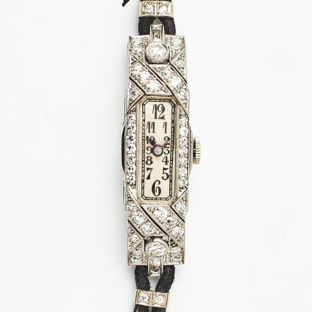 DAMARMBANDSUR, platina, manuell, arabiska siffror, plexiglas, dekor av 2 baguetteslipade diamanter, samt små åttkant-och briljantslipade diamanter, art deco.