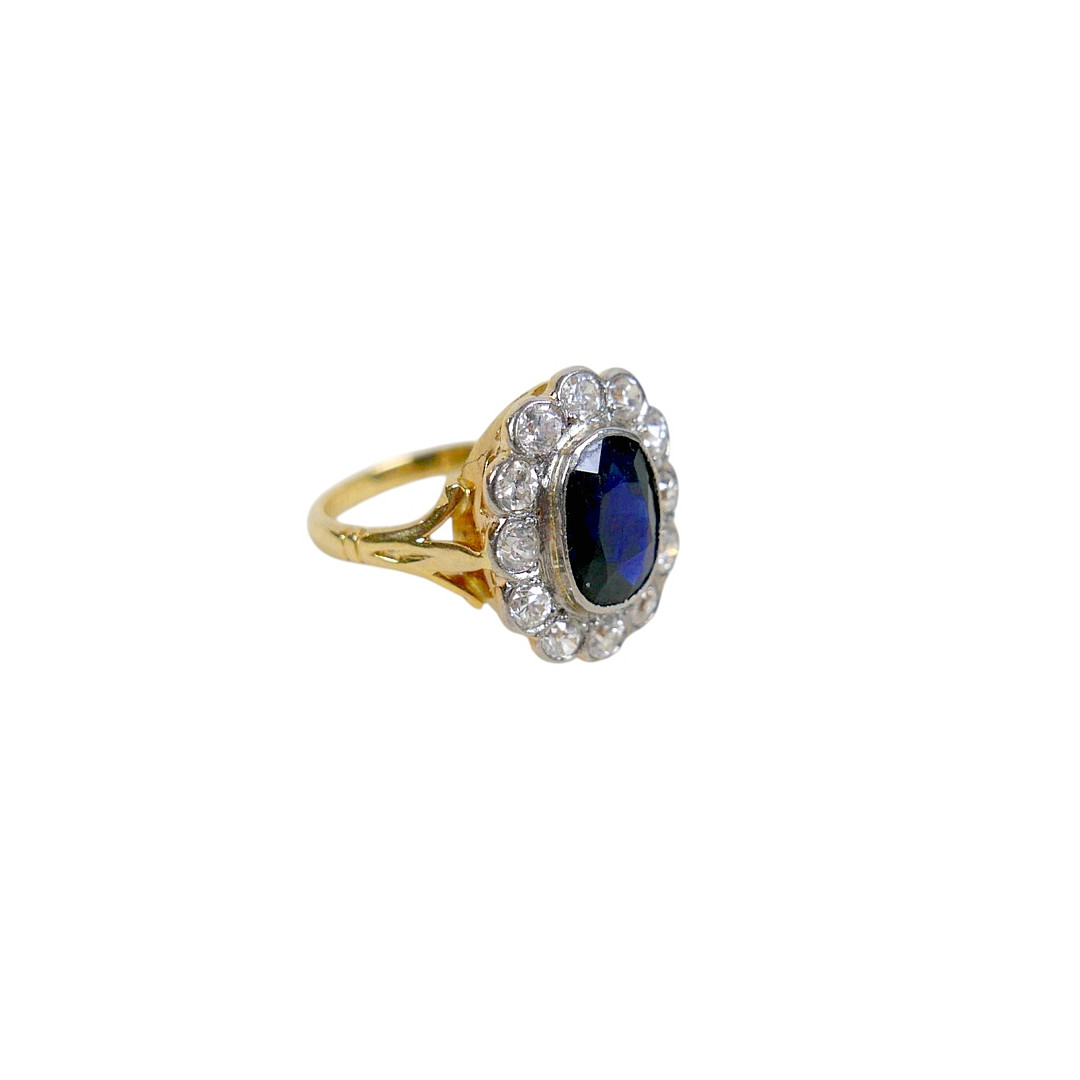 AN 18CT GOLD AND PLATINUM SET SAPPHIRE AND DIAMOND FLOWER RING.