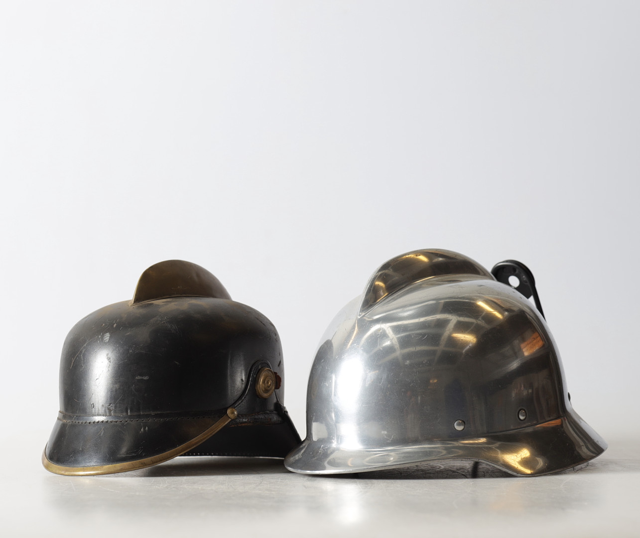 KASKAR, 2 st, för brandförsvaret, metall & läder, Sverige & Tyskland, 1900-tal.