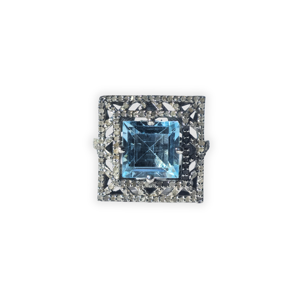 Anillo en plata con baño de rutenio y topacio orlado por diamantes.
