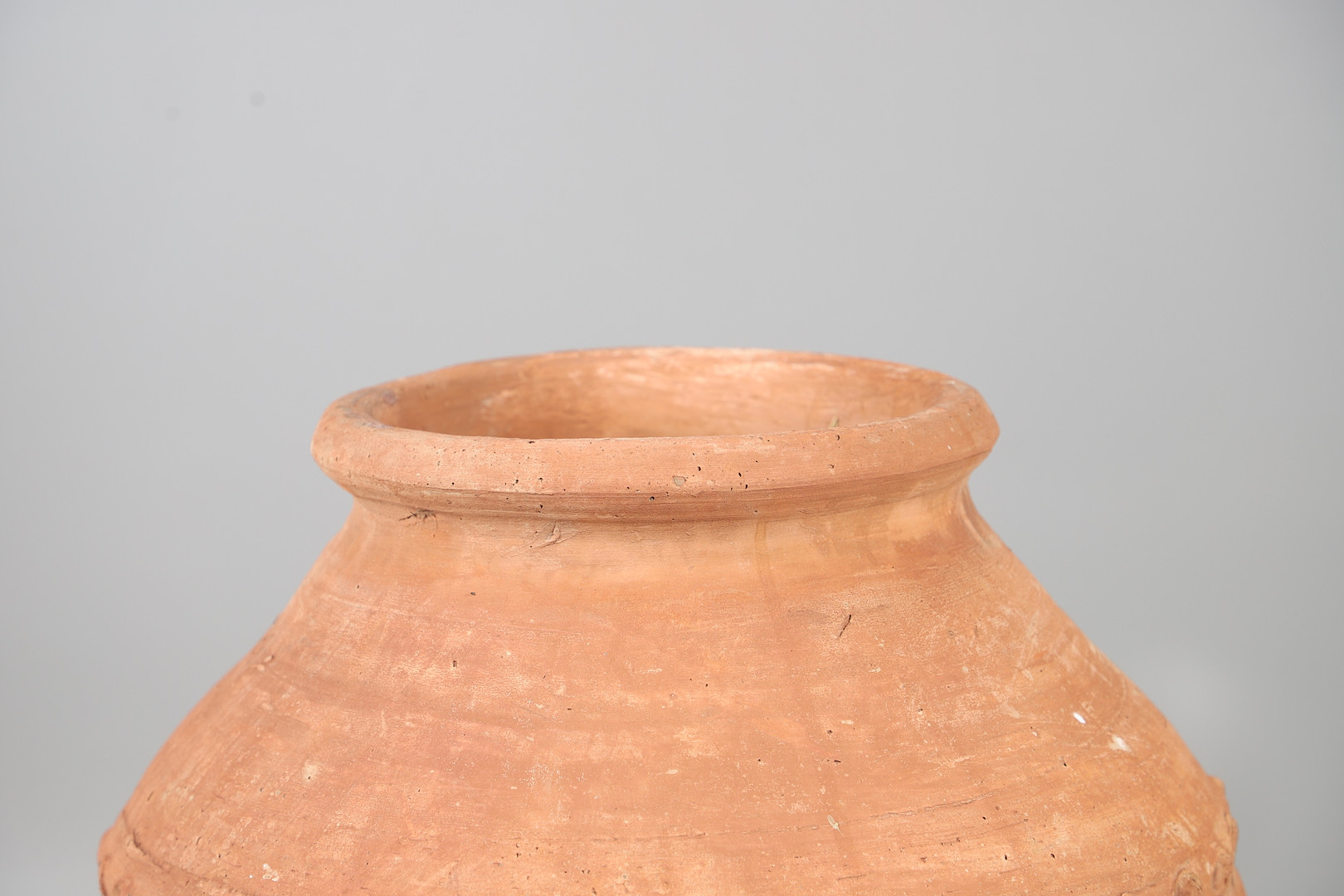 A TERRACOTTA OLIVE (?) JAR ON METAL STAND.