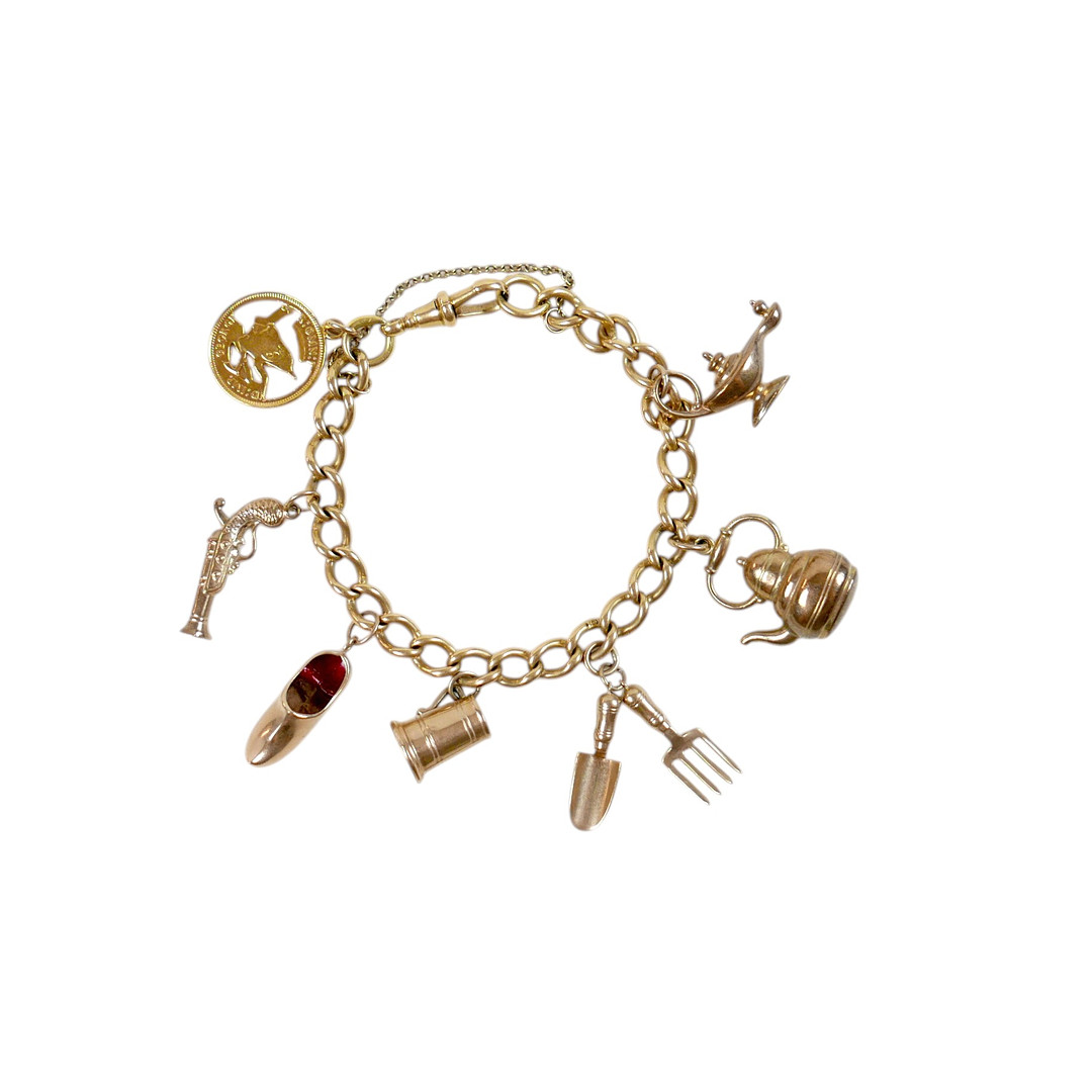 AN 18CT GOLD CHARM BRACELET WITH ASSORTED 9CT CHARMS.