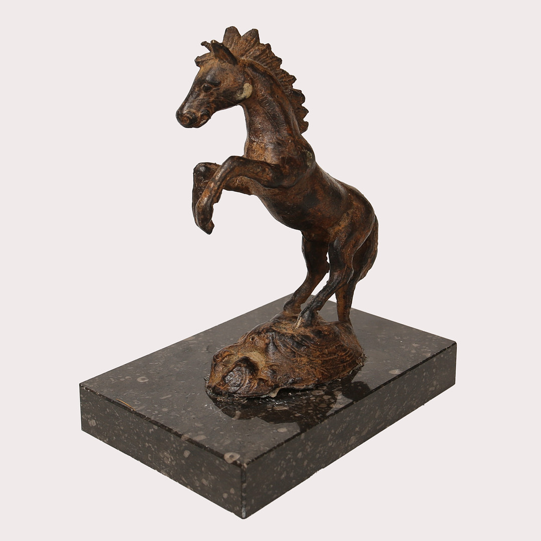 SKULPTUR i form av en stegrande häst på stensockel, 1900- tal.