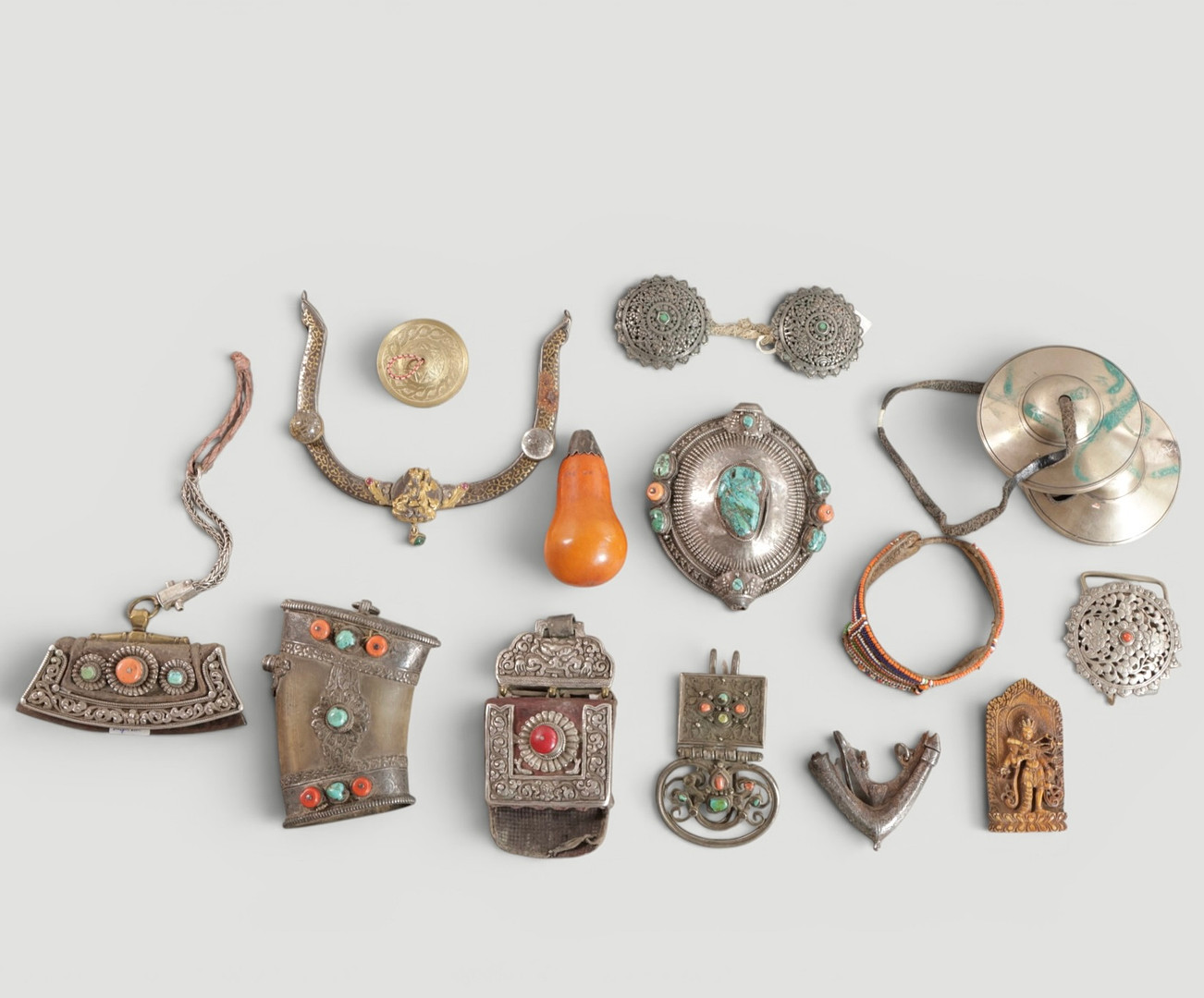 Samling beklædningsgenstande, vedhæng mm. metal dekoreret med ædelsten, ben mm. Tibet, 19. årh. (16).