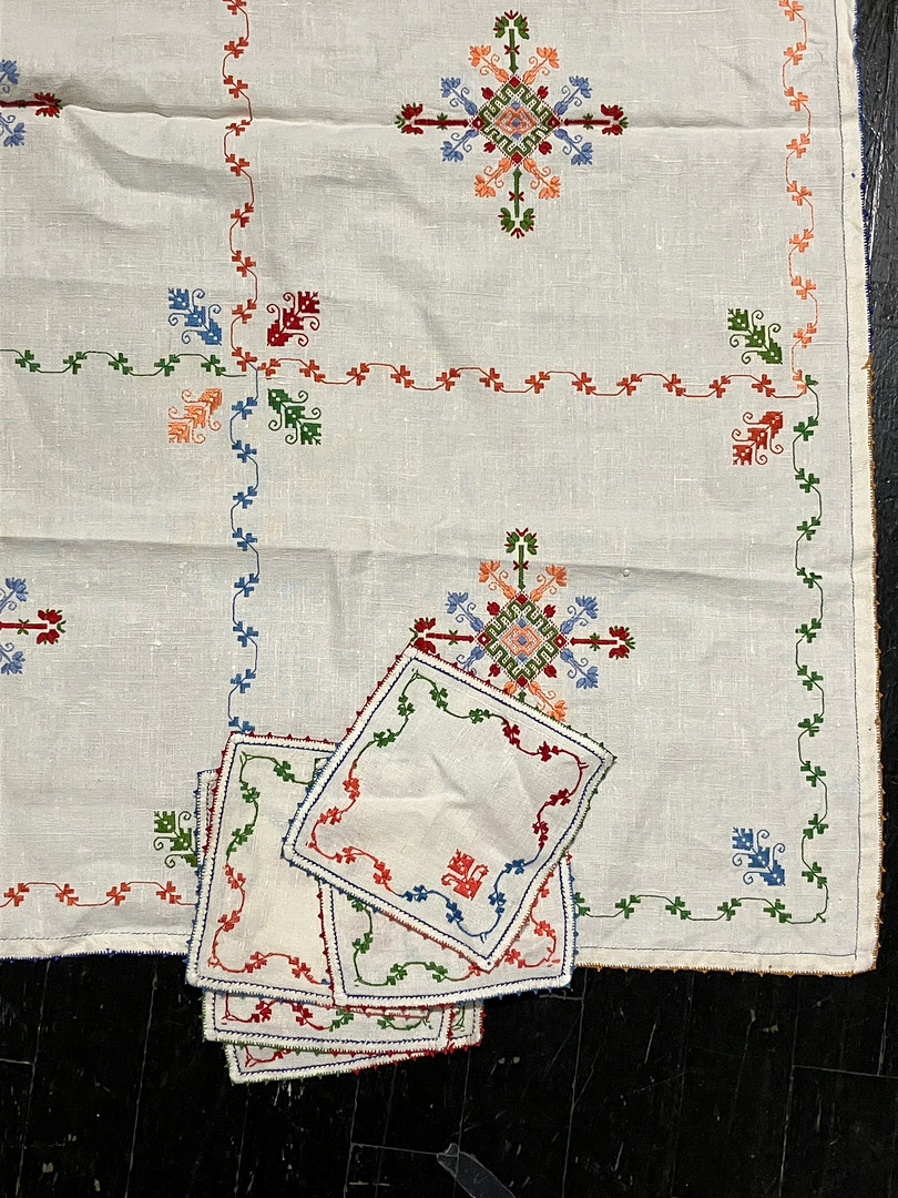 Tablecloth and six placemats set in embroidered linen with ethnic motifs, 20th Century.