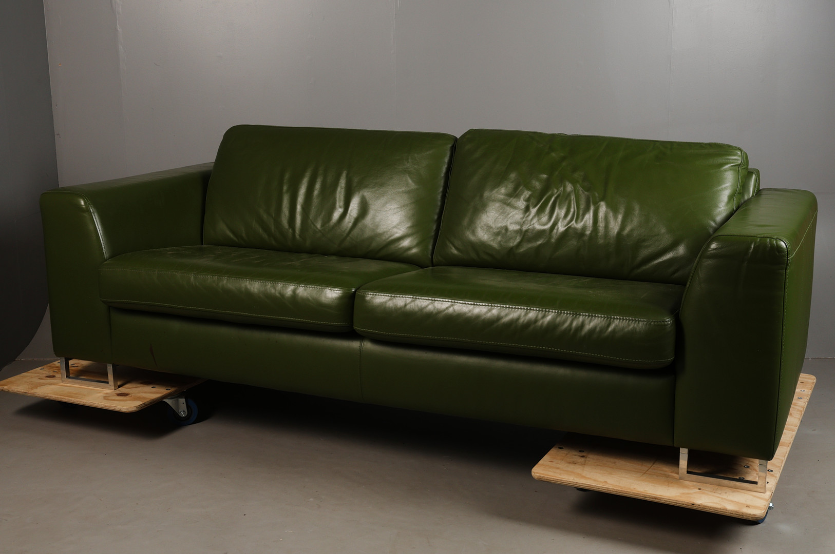 GREEN UPHOLSTERED SETTEE.