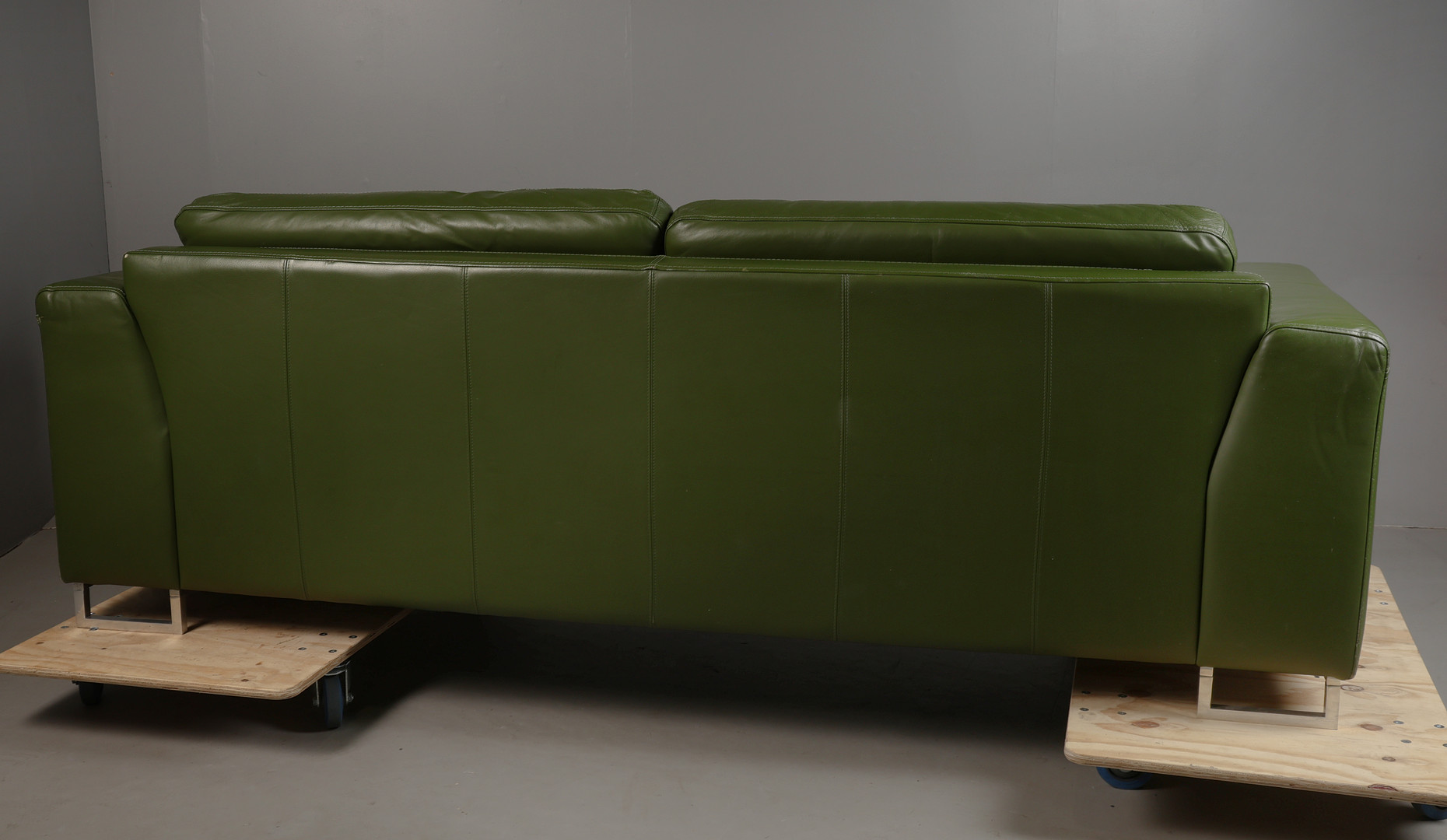 GREEN UPHOLSTERED SETTEE.
