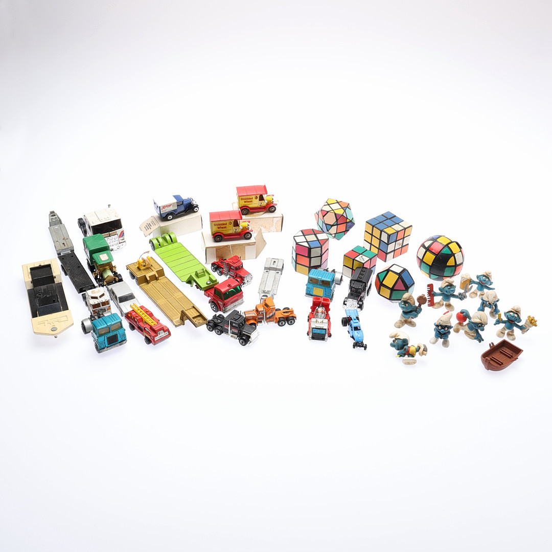MODEL LORRIES, SCHLEICH SMURFS, AND RUBIK'S CUBES.