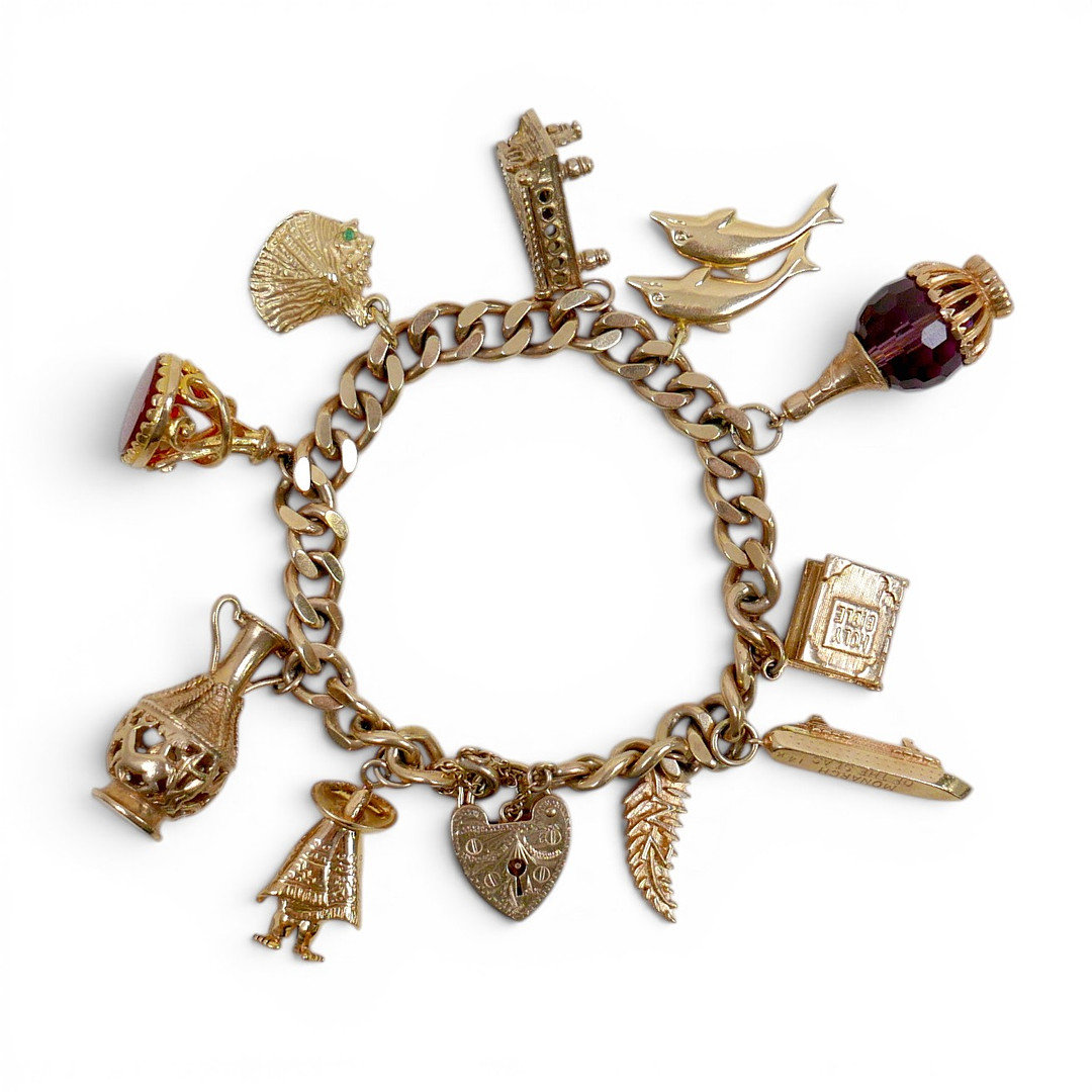 A 9CT GOLD CHARM BRACELET, FLAT CURB, WITH ASSORTED 9CT AND 14CT GOLD CHARMS.