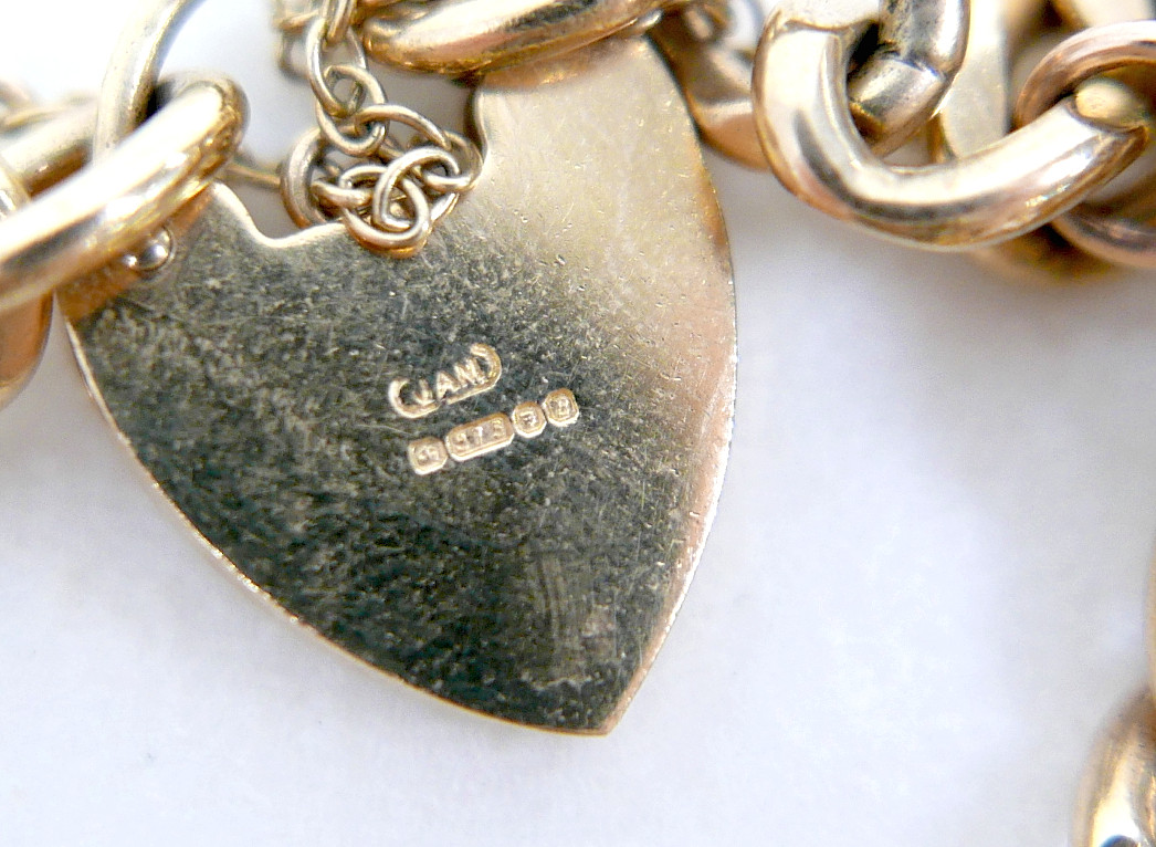 A 9CT GOLD CHARM BRACELET, FLAT CURB, WITH ASSORTED 9CT AND 14CT GOLD CHARMS.