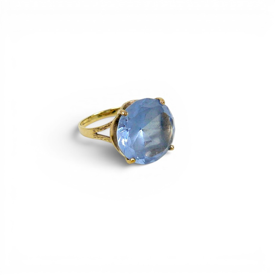 A 9CT GOLD RING WITH LARGE FACETED BLUE STONE, POSSIBLY TOPAZ.