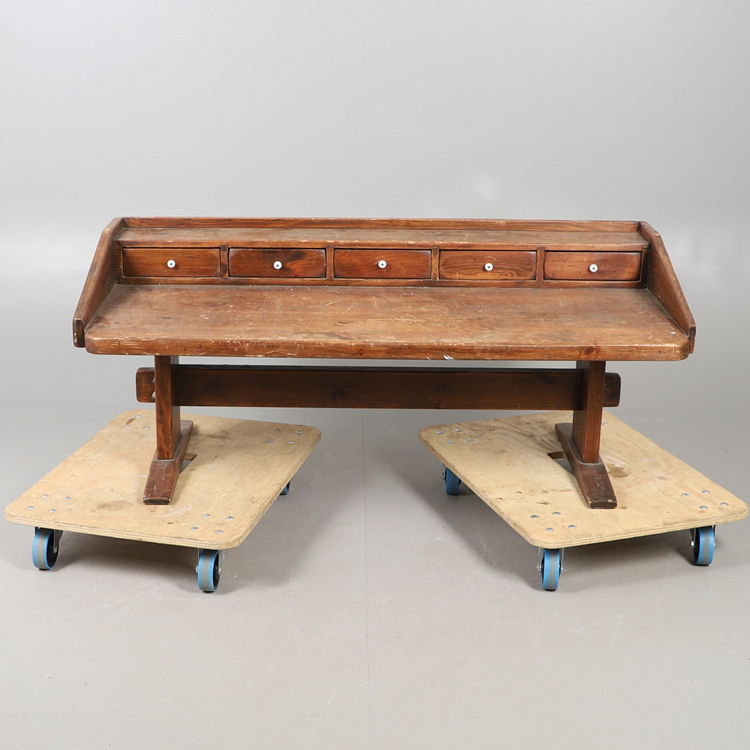 A STAINED PINE WORK BENCH.