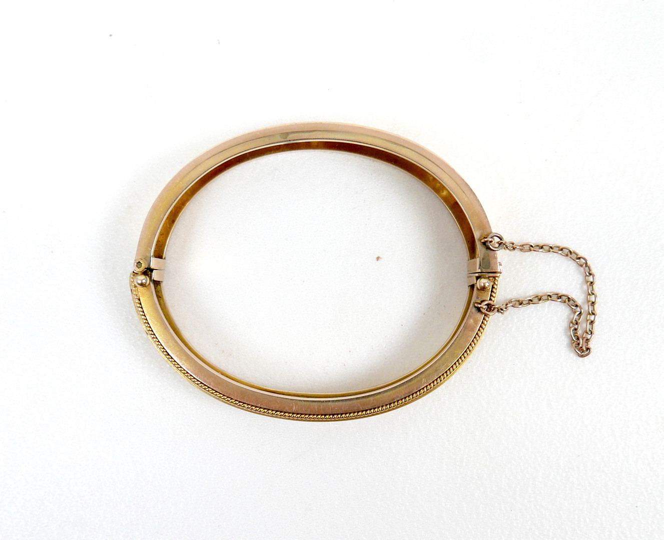 A 19TH/EARLY 20TH CENTURY YELLOW METAL AND DIAMOND HINGED BANGLE.