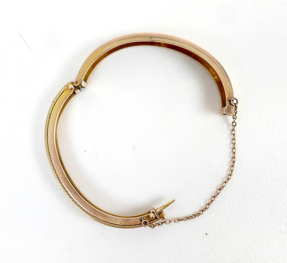 A 19TH/EARLY 20TH CENTURY YELLOW METAL AND DIAMOND HINGED BANGLE.