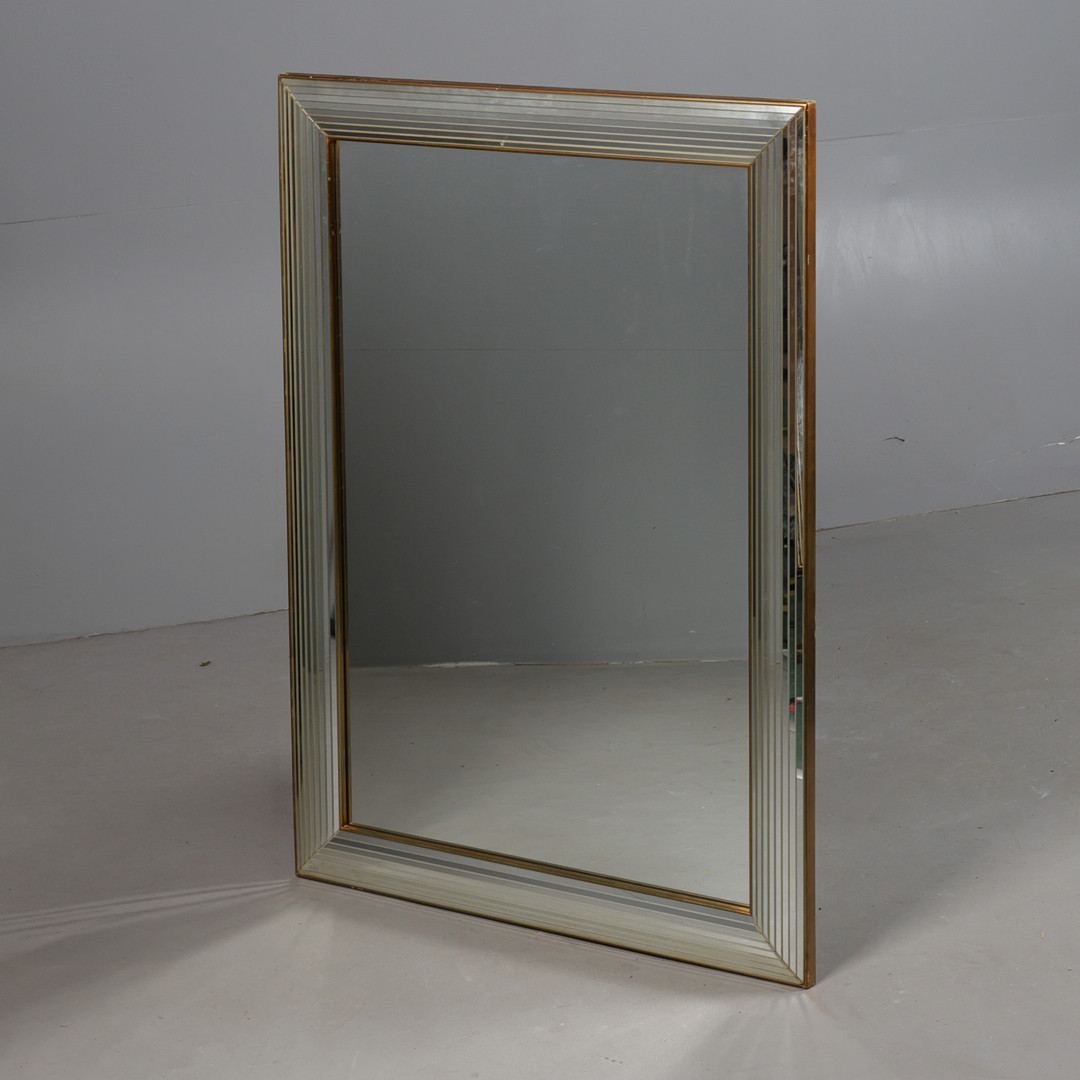 A CONTINENTAL GILT FRAMED AND BEVELLED WALL MIRROR.