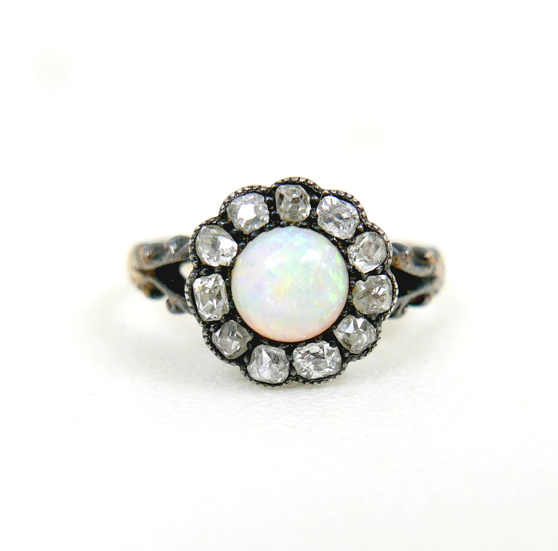 AN 18CT GOLD OPAL AND DIAMOND DAISY RING.