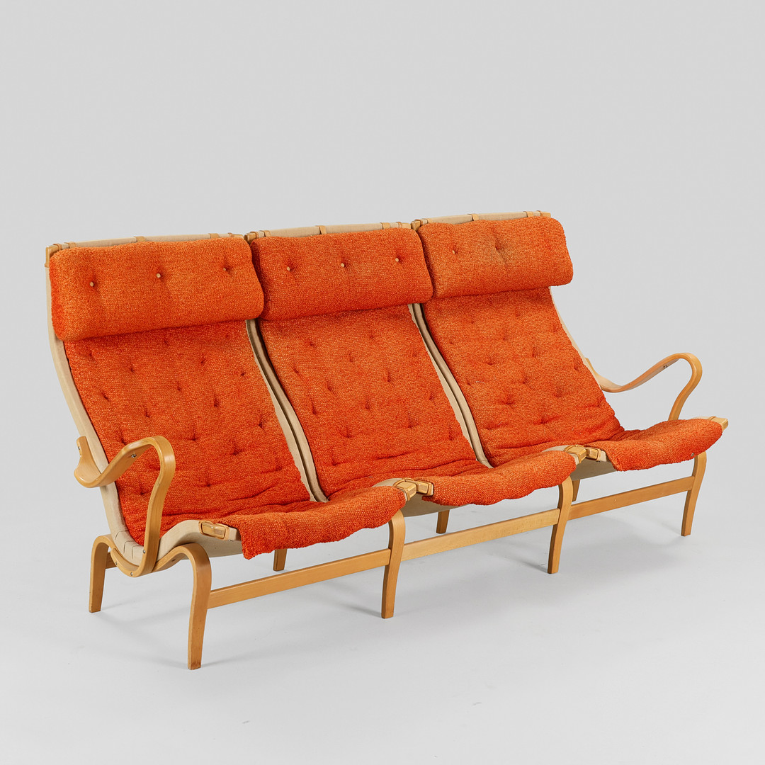 BRUNO MATHSSON. "Pernilla", sofa af formbøjet bøg og kanvas, detaljer af læder og hynder betrukket med orange møbelstof, Dux, Sverige, 1900-tallets anden halvdel.