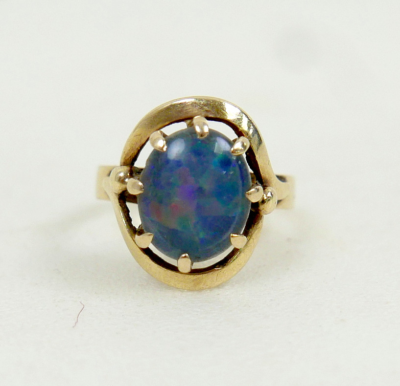 A 9CT GOLD OPAL SOLITAIRE RING.