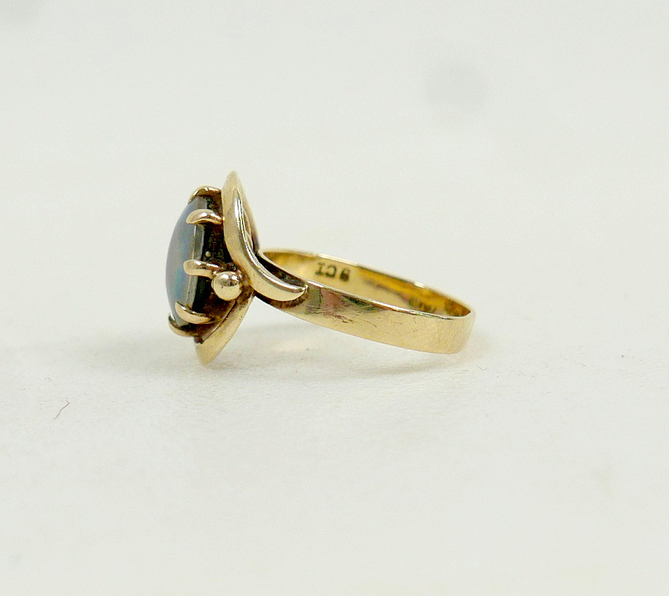 A 9CT GOLD OPAL SOLITAIRE RING.