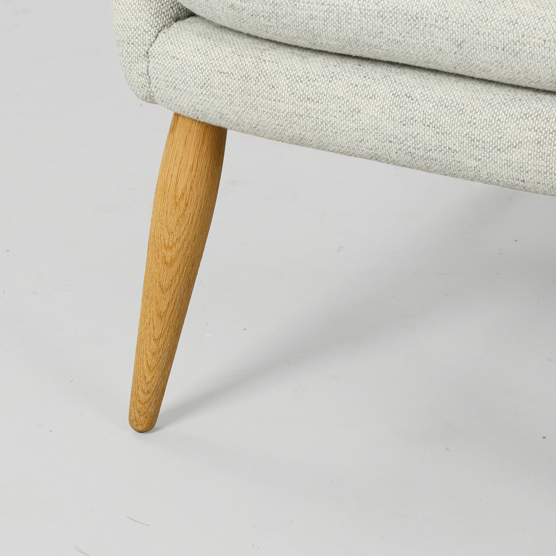 ARNOLD MADSEN (1907-1989). 'Oda' lænestol fremstillet i massivt egetræ og gråt Hallingdal 65 tekstil fra Kvadrat, Audo Copenhagen, Danmark, formgivet i 1956.