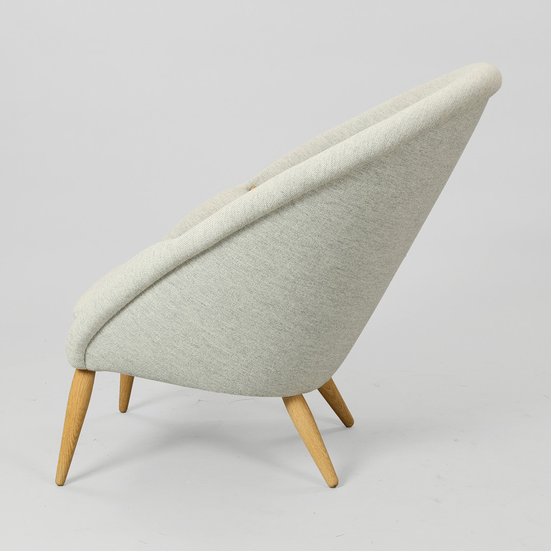 ARNOLD MADSEN (1907-1989). 'Oda' lænestol fremstillet i massivt egetræ og gråt Hallingdal 65 tekstil fra Kvadrat, Audo Copenhagen, Danmark, formgivet i 1956.