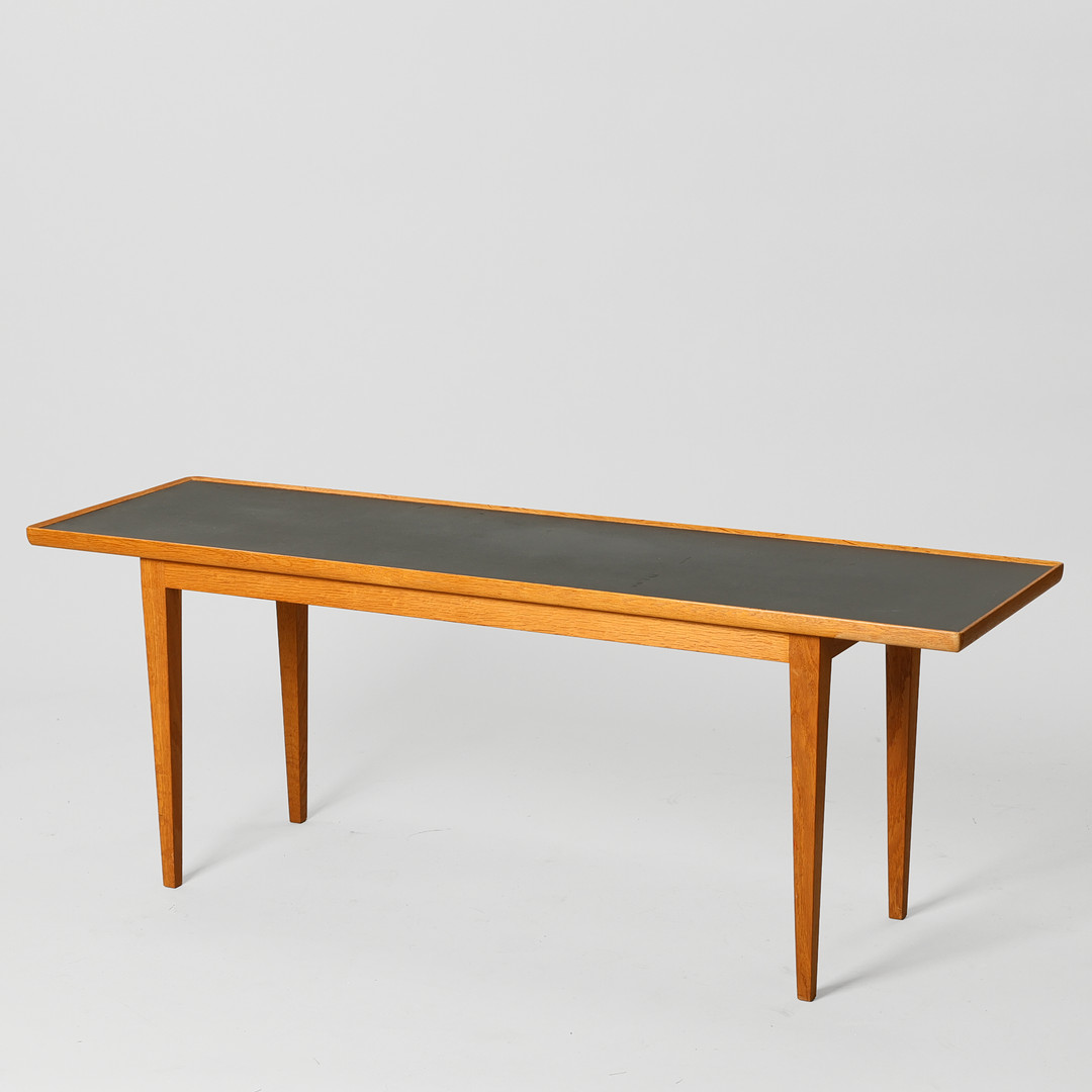 FRITS HENNINGSEN. Aflangt sofabord af eg med tilspidsede ben, top med sort laminat, Danmark, 1960'erne.