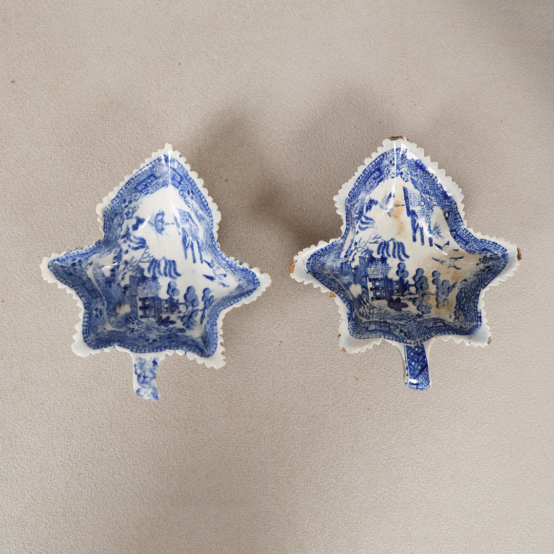 A PAIR OF EARLY 19TH CENTURY BLUE AND WHITE PEARLWARE "WILLOW PATTERN" LEAF SHAPED PICKLE DISHES (2).