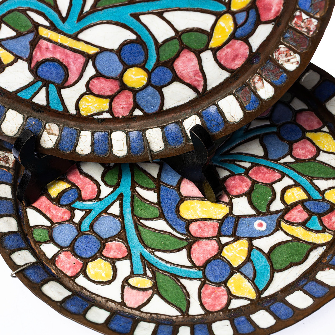 VÄGGFAT, ett par, dekor i relief av stiliserad fågel och blomster i polykrom emalj, 1900-talets mitt.