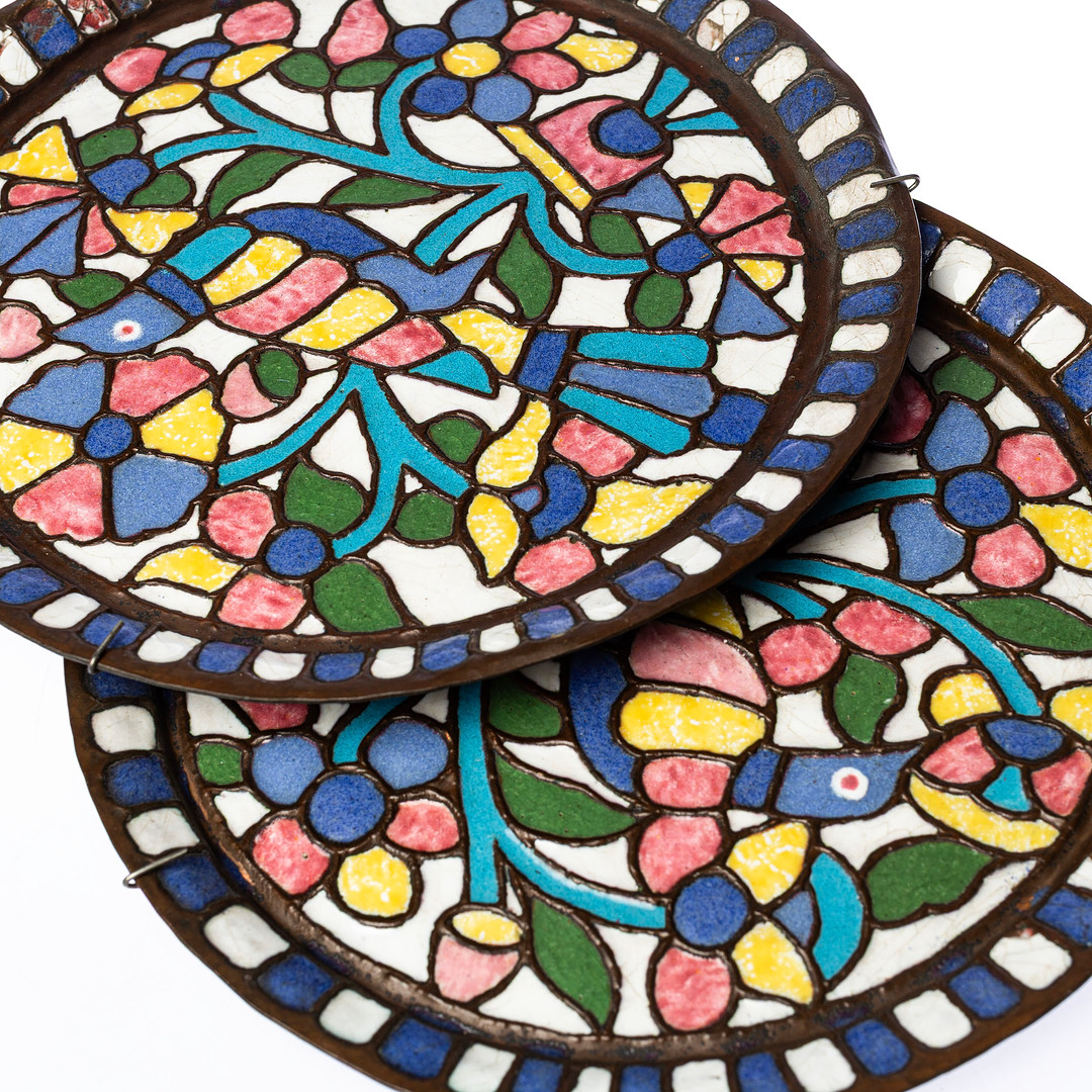 VÄGGFAT, ett par, dekor i relief av stiliserad fågel och blomster i polykrom emalj, 1900-talets mitt.